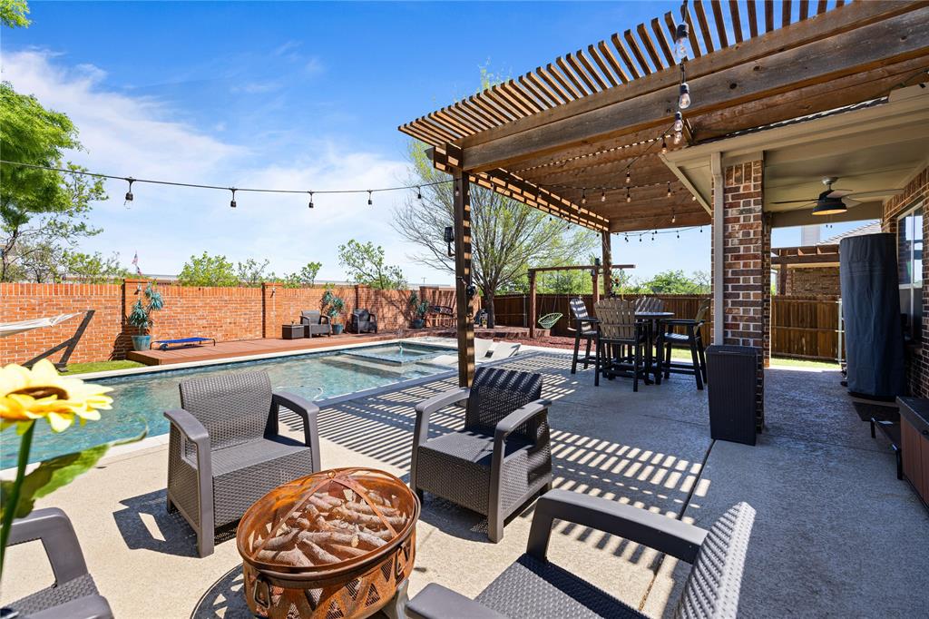 View of patio / terrace with a fenced in pool, ceiling fan, a fire pit, and a pergola