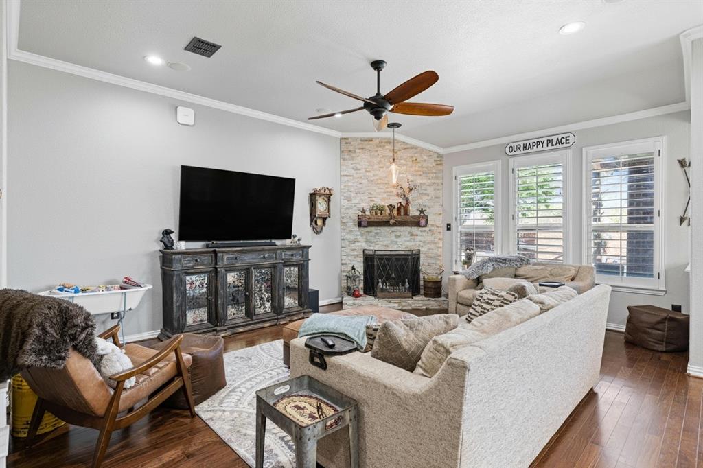 Living area featuring a corner fireplace with a stone surround and wood mantel Living area featuring a corner fireplace with a stone surround and wood mantel