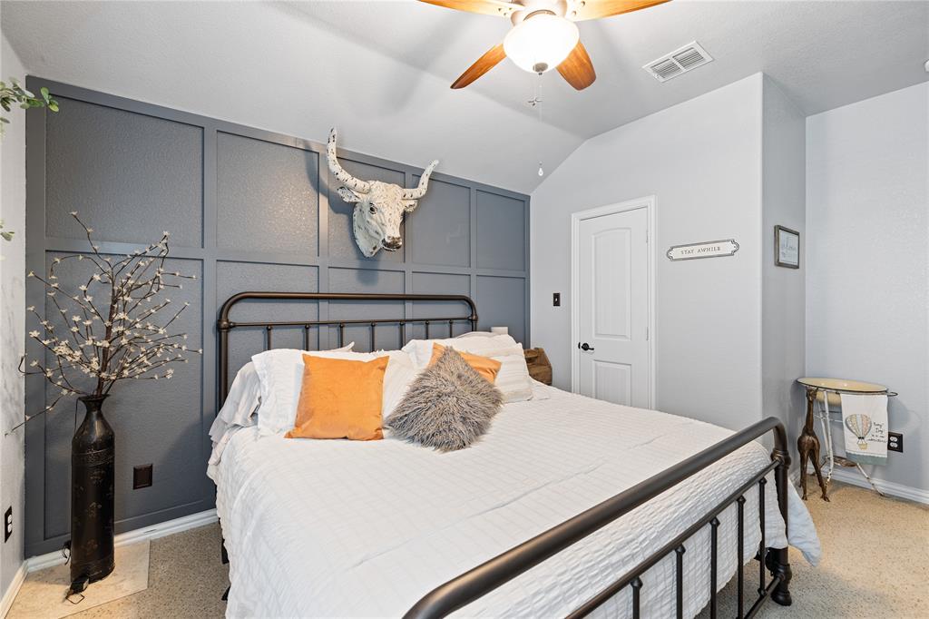 Bedroom featuring light colored carpet, lofted ceiling, and ceiling fan