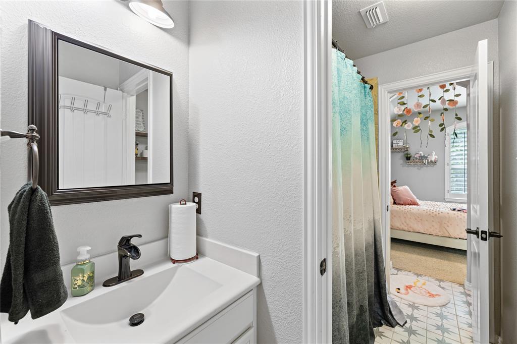 Bathroom featuring tile flooring, vanity, and a textured ceiling