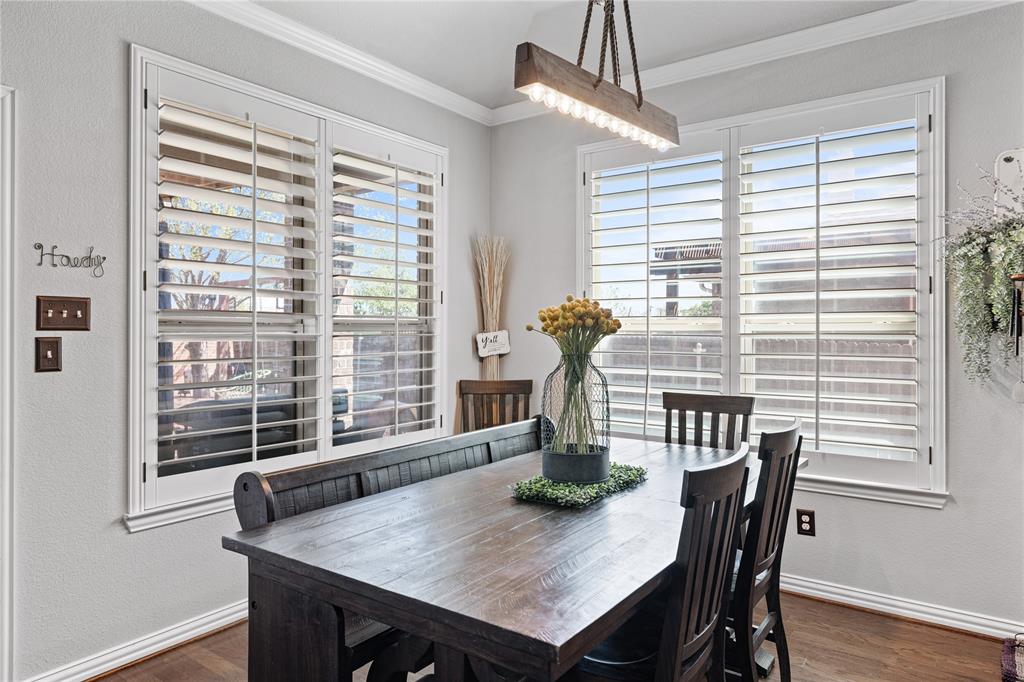 Dining space with a wealth of natural light, ornamental molding, and dark hardwood / wood-style flooring