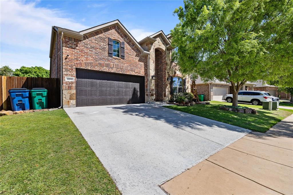 View of front of property featuring a front lawn and a garage