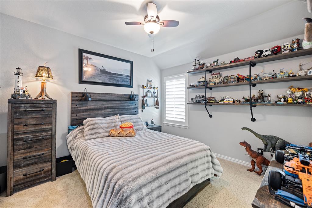Bedroom with ceiling fan and light carpet