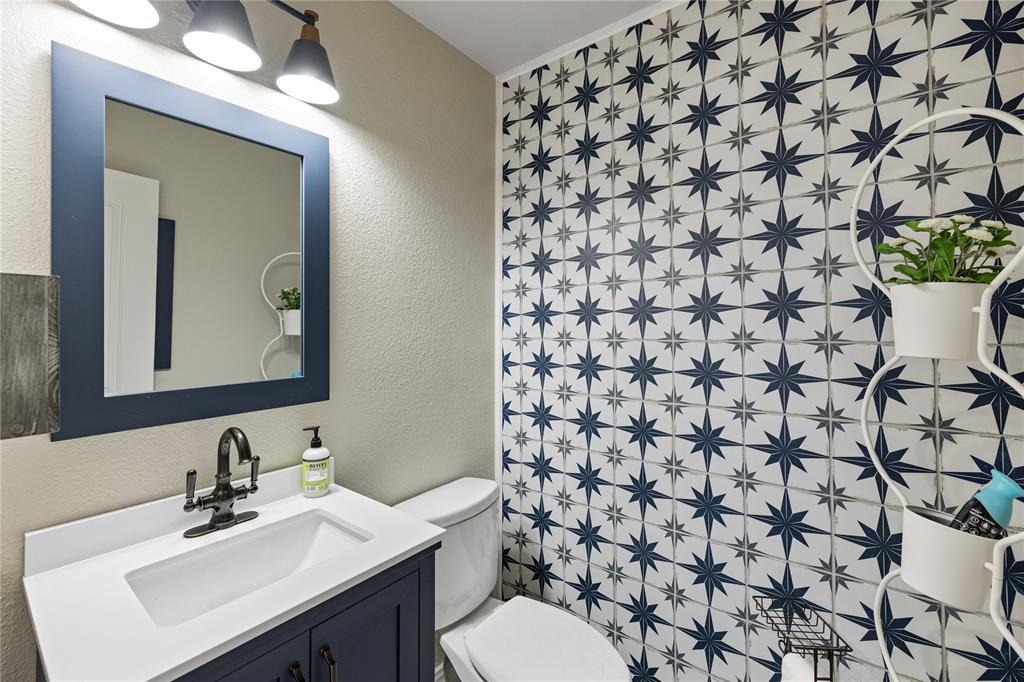 Bathroom featuring oversized vanity, toilet, and tile flooring