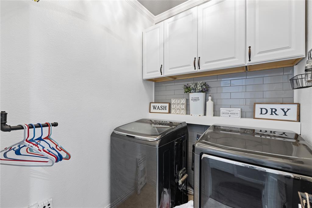 Laundry room with cabinets and washer and clothes dryer