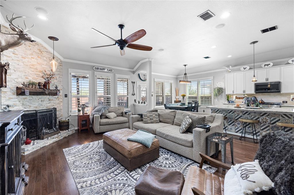 Living room featuring ornamental molding, ceiling fan, a wealth of natural light, and dark hardwood / wood-style floors