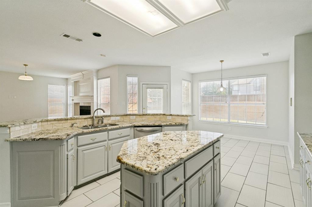Kitchen featuring a central island with countertop, coordinating perimeter countertops with a tile backsplash, light-toned cabinetry, and stainless steel appliances