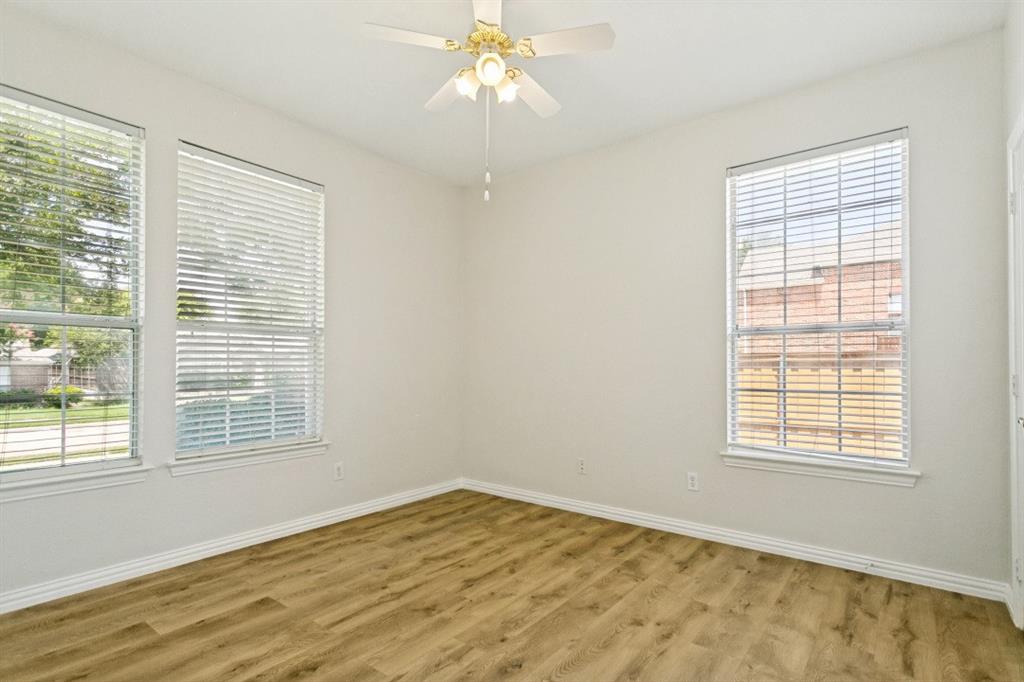 Room featuring wood-finish flooring, white baseboards, and neutral wall paint