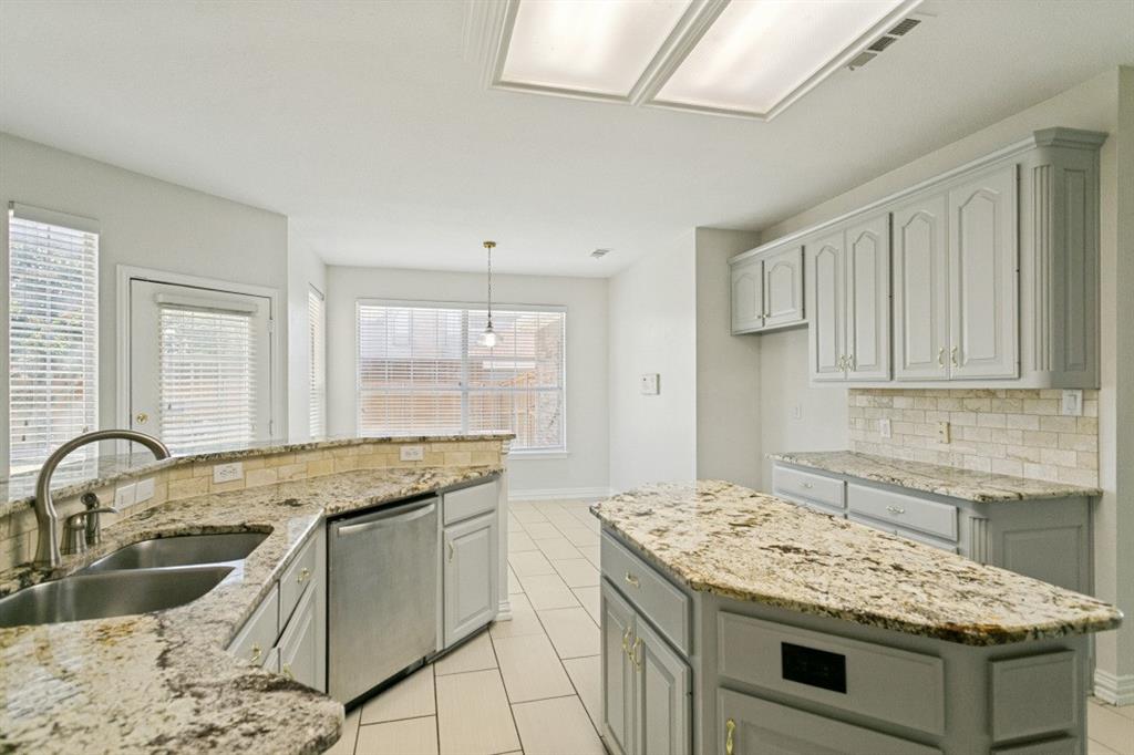 Kitchen featuring light-toned cabinetry, granite countertops, tile flooring, and a subway tile backsplash
