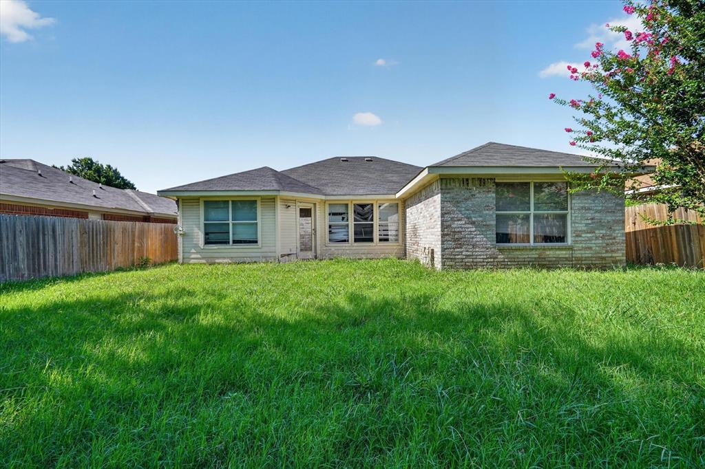Expansive backyard featuring a lush lawn and perimeter wood fencing