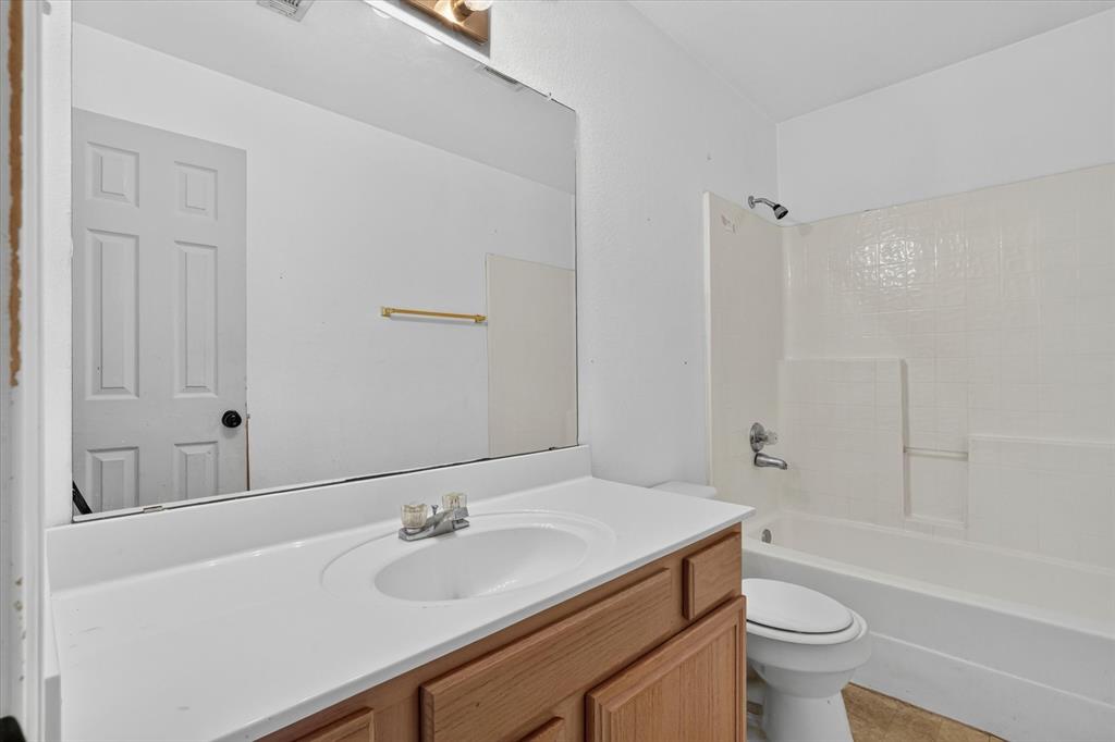 Bathroom featuring a light wood-finish vanity with a white countertop and integrated sink