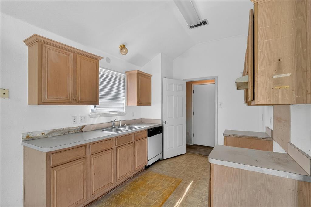 Kitchen featuring light wood cabinetry and light-toned countertops