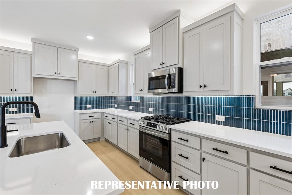 With ample cabinetry, gorgeous counter tops and designer backsplash, all the chefs in the family will love creating in this dream kitchen!  REPRESENTATIVE PHOTO