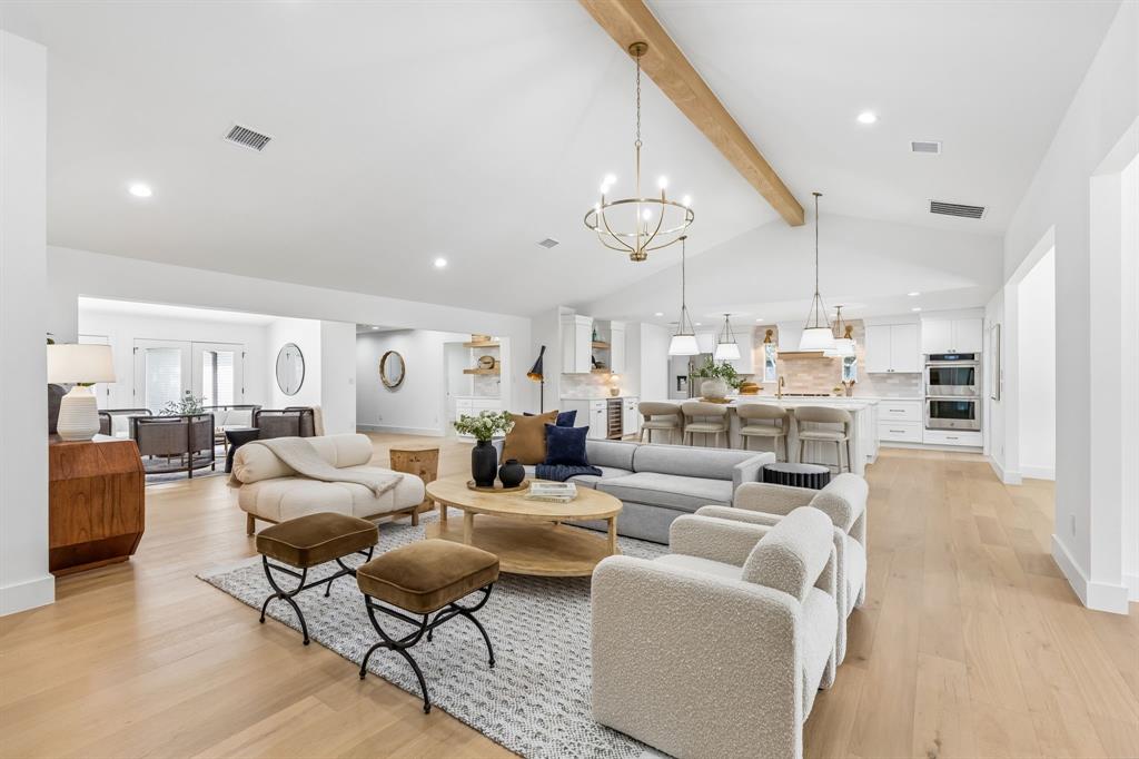 Expansive versatile room with beam ceiling,fireplace,and open to kitchen