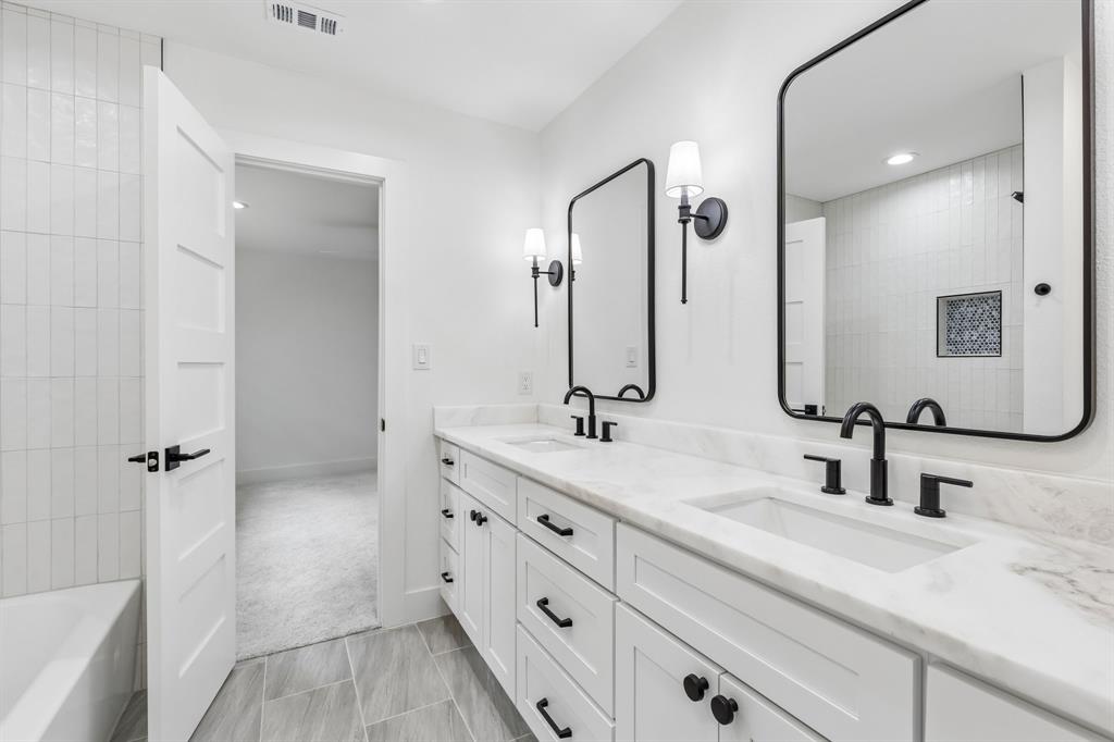 Jack and jill bathroom includes bathrub,dual sinks,and plenty of storage