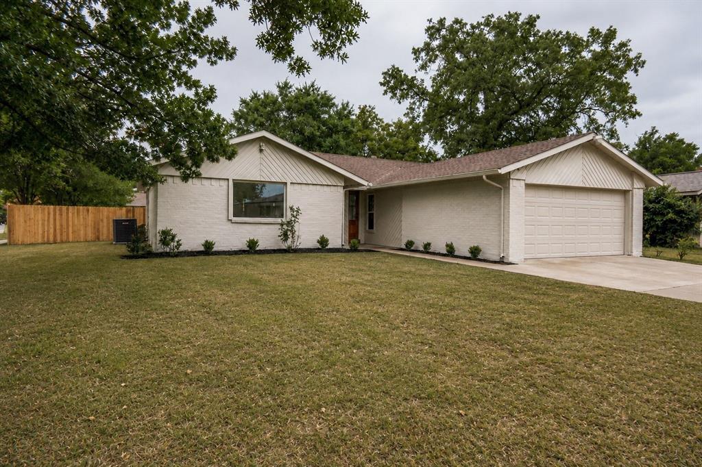 Single-story residence featuring a two-car garage, brick exterior, and a new privacy fence