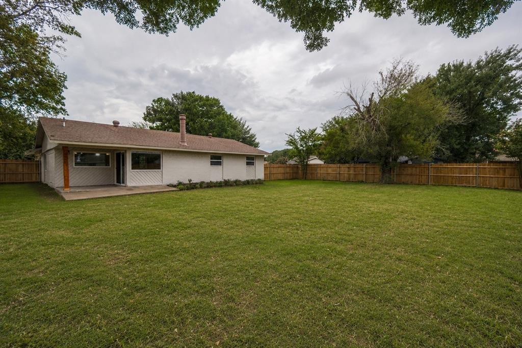 Expansive grassy lawn with a wood privacy fence