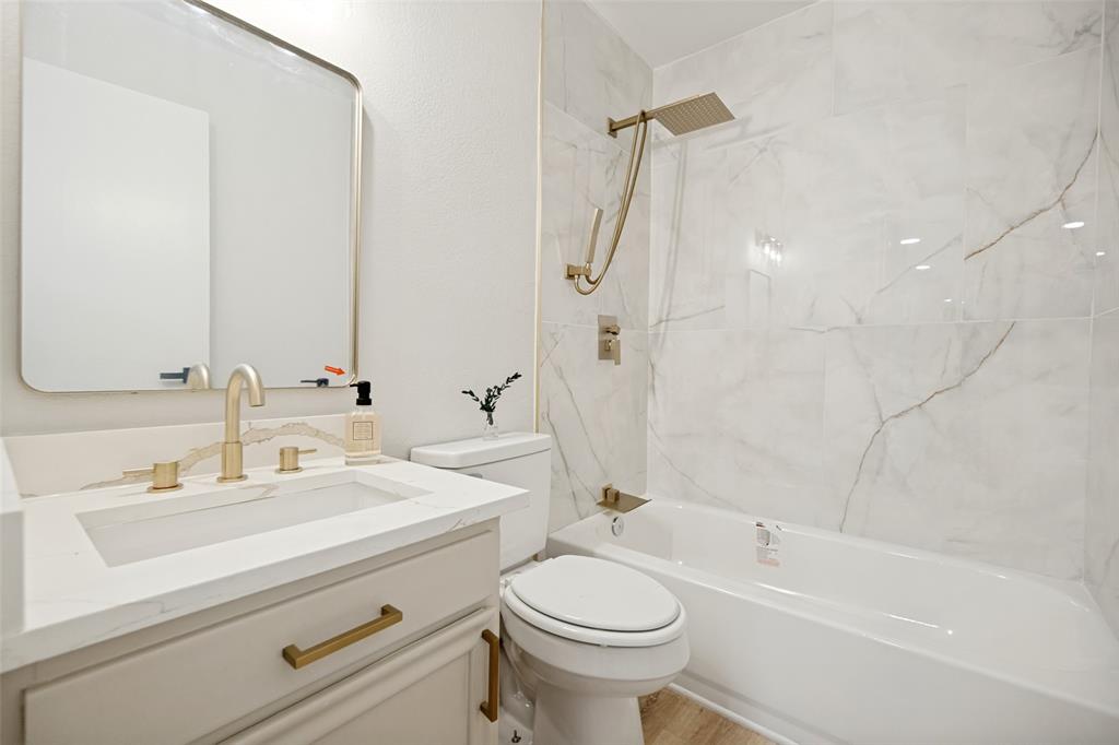 Bathroom featuring a white vanity with a rectangular basin sink and gold-tone fixtures