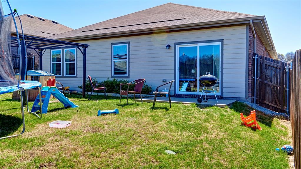 Private backyard with a sliding glass door, multiple windows, and a wood privacy fence