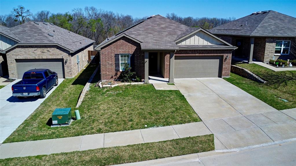 Brick facade with an attached two-car garage, concrete driveway, and a front walkway