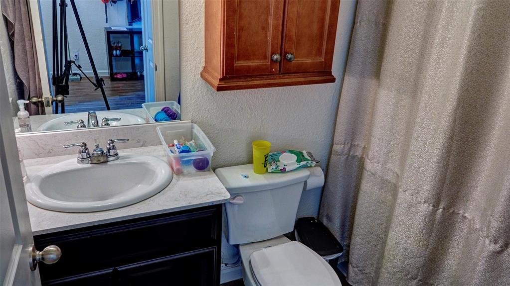 White vanity with a single basin, chrome fixtures, and dark cabinetry