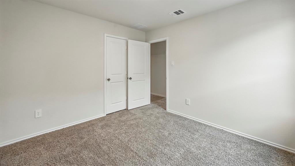 Neutral-toned interior room featuring light gray carpeting and white baseboards