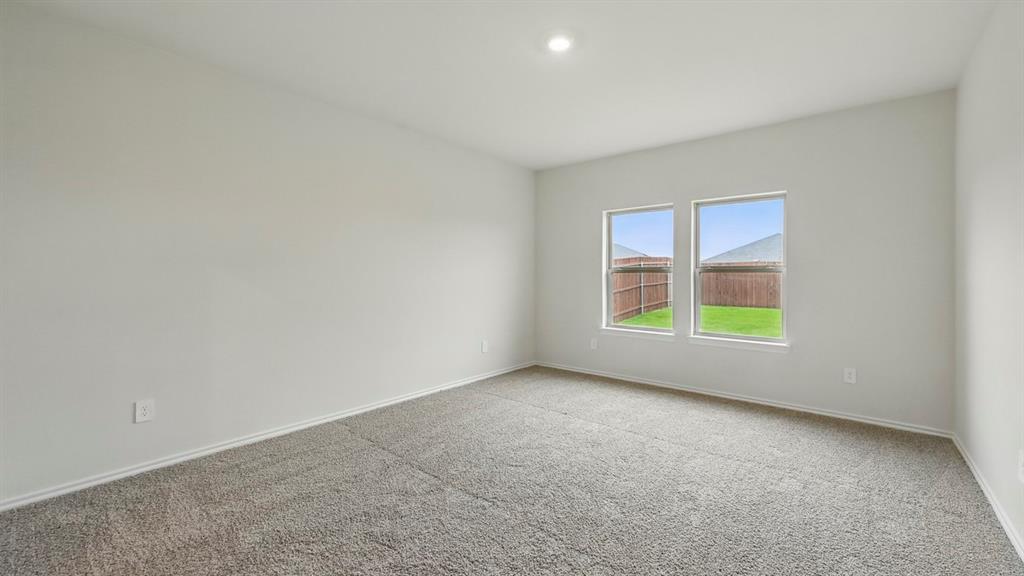Carpeted room with light-colored walls and baseboards Carpeted room with light-colored walls and baseboards