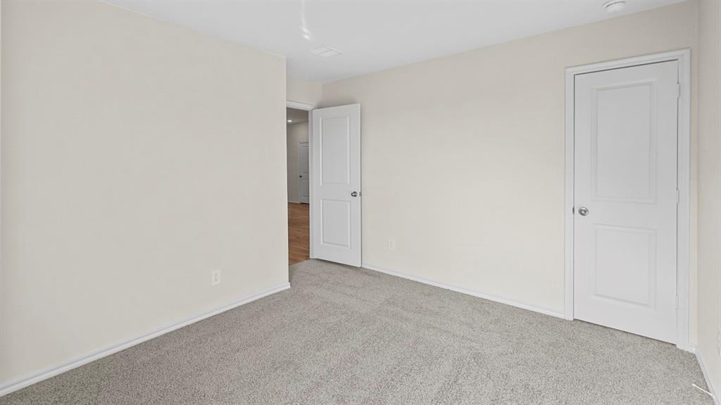 Neutral-toned walls complement plush grey carpeting