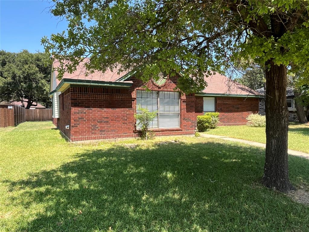 Red brick exterior with a pitched roof, front-facing window, and established perimeter fencing Red brick exterior with a pitched roof, front-facing window, and established perimeter fencing