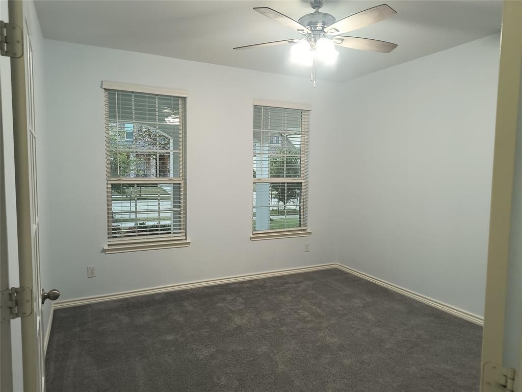 Room featuring two windows with horizontal blinds, neutral wall paint, and gray carpet flooring