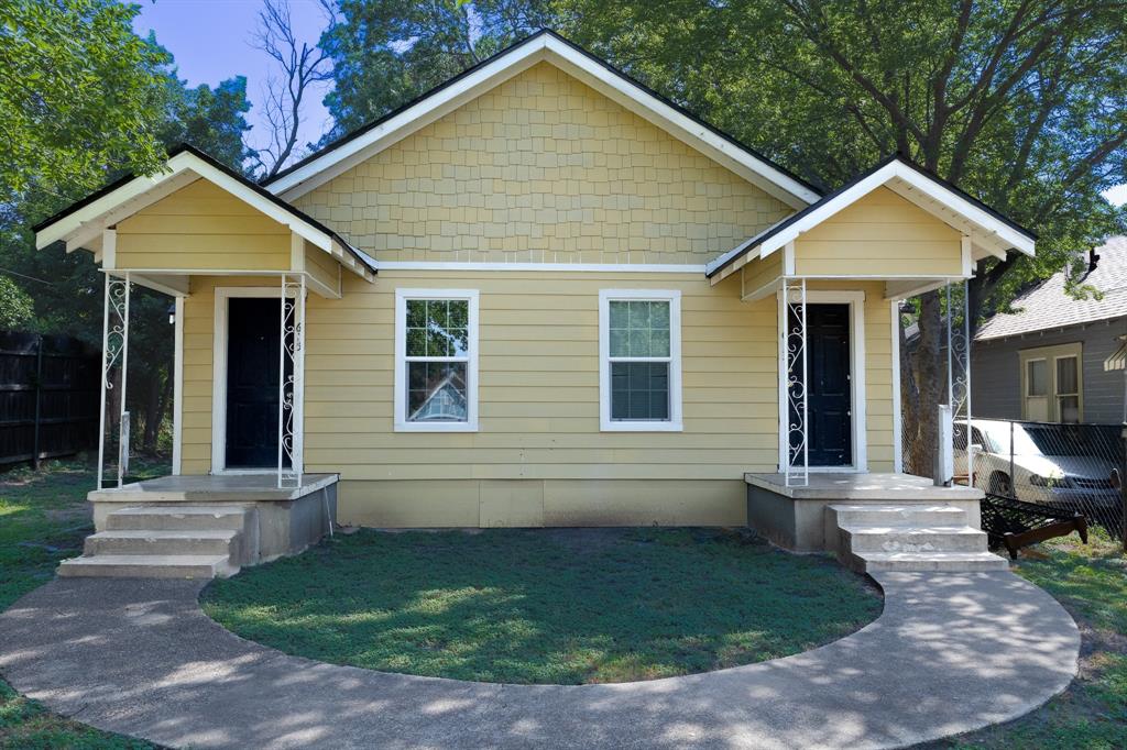Duplex exterior featuring light yellow siding and a shingle-style gable accent Duplex exterior featuring light yellow siding and a shingle-style gable accent