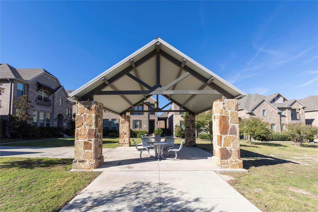 Outdoor pavilion with stone-clad pillars in front of the property.