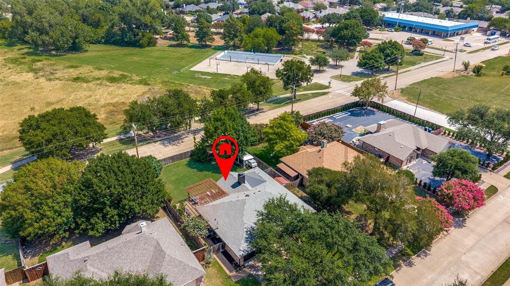 Aerial perspective highlighting a residential property with a gray impact rated shingle roof and mature surrounding trees
