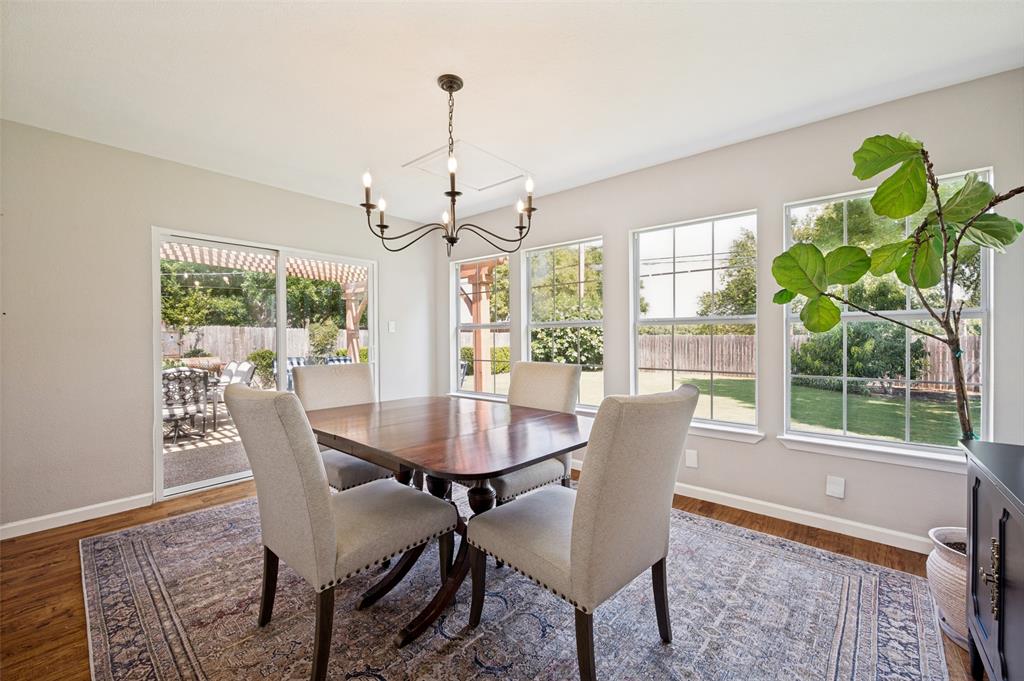 Formal Dining space featuring a classic chandelier and multiple views of landscaped yard and patio.  Depending on your lifestyle, this room can easily be repurposed.
