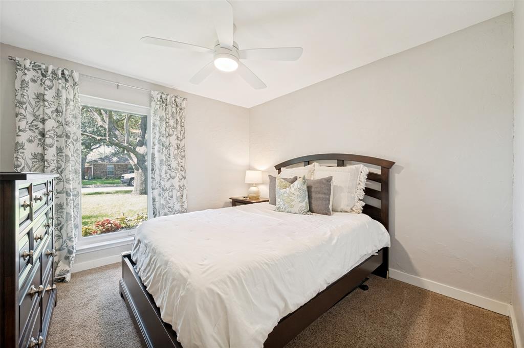 2nd Bedroom with ceiling fan, light-colored walls, carpet flooring, and window with exterior landscaping views - makes for lovely Guest quarters.