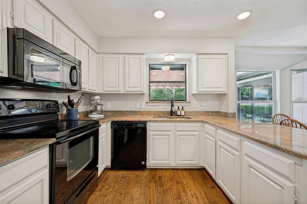 Black appliances accent the modern kitchen cabinetry and contrast beautifully with the Granite countertops.