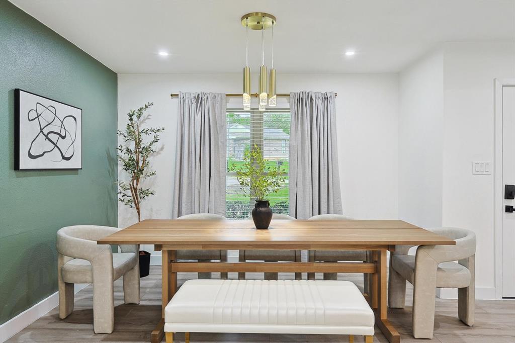 Dining space featuring wood-finish flooring, a contemporary chandelier, recessed lighting, and a window with blinds Dining space featuring wood-finish flooring, a contemporary chandelier, recessed lighting, and a window with blinds