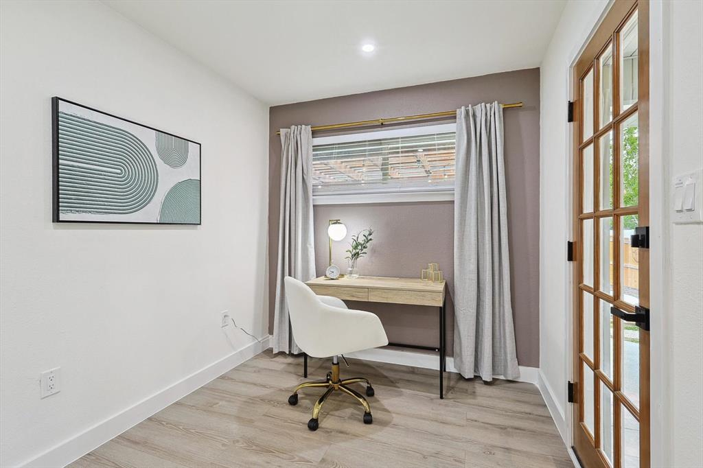 Interior room with wood-finish flooring, recessed lighting, a window with blinds, and a glass-paneled wooden door with black hardware