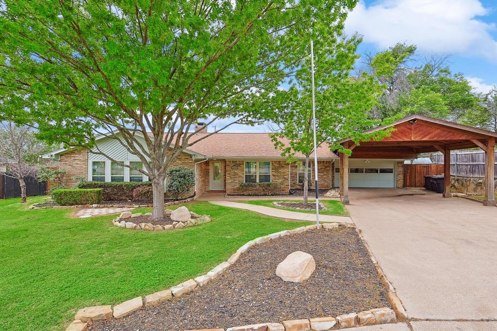 Brick exterior residence featuring a covered carport, attached garage, and a concrete driveway Brick exterior residence featuring a covered carport, attached garage, and a concrete driveway