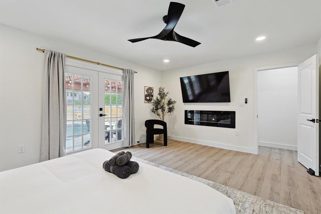 Spacious interior with light wood-finish flooring, a contemporary ceiling fan, and recessed lighting