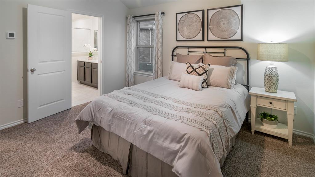 Carpeted bedroom featuring a window with patterned drapes, a white paneled door, and a thermostat