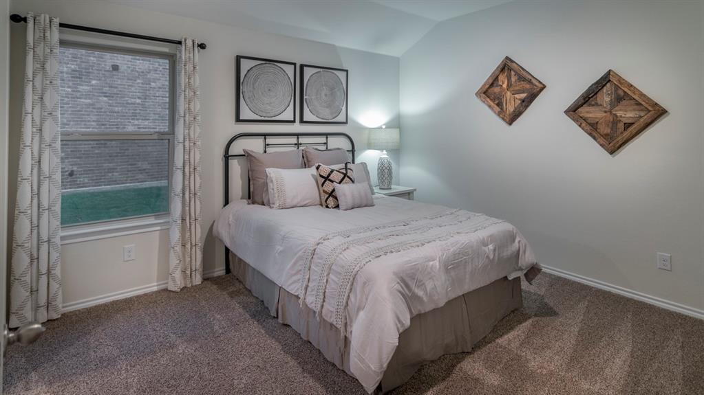 Carpeted bedroom featuring a double-hung window, crown molding, and a sloped ceiling