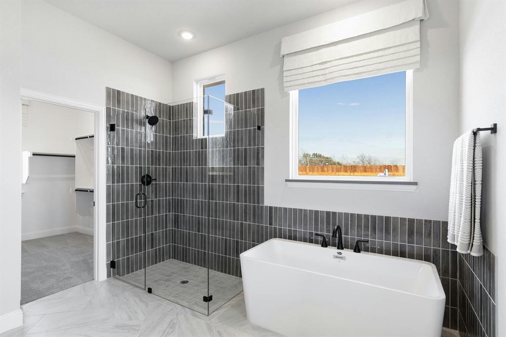 Master bathroom shower and tub of Kentsdale Farms home in DeSoto, TX by Kindred Homes