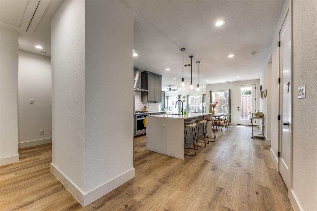 Open concept living area featuring wood-finish flooring, recessed lighting, and a contemporary kitchen