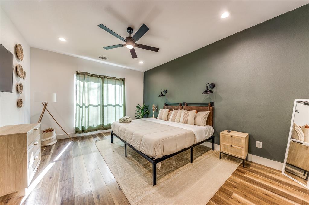 Spacious room featuring wood-finish flooring, a contemporary ceiling fan, and recessed lighting