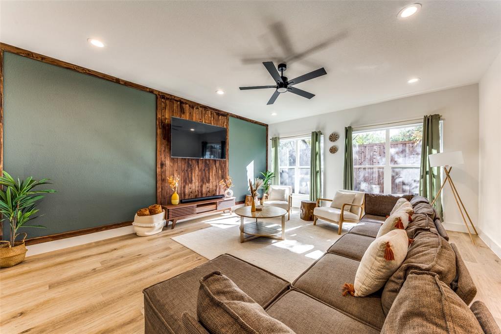 Spacious living area featuring wood-finish flooring and recessed ceiling lighting