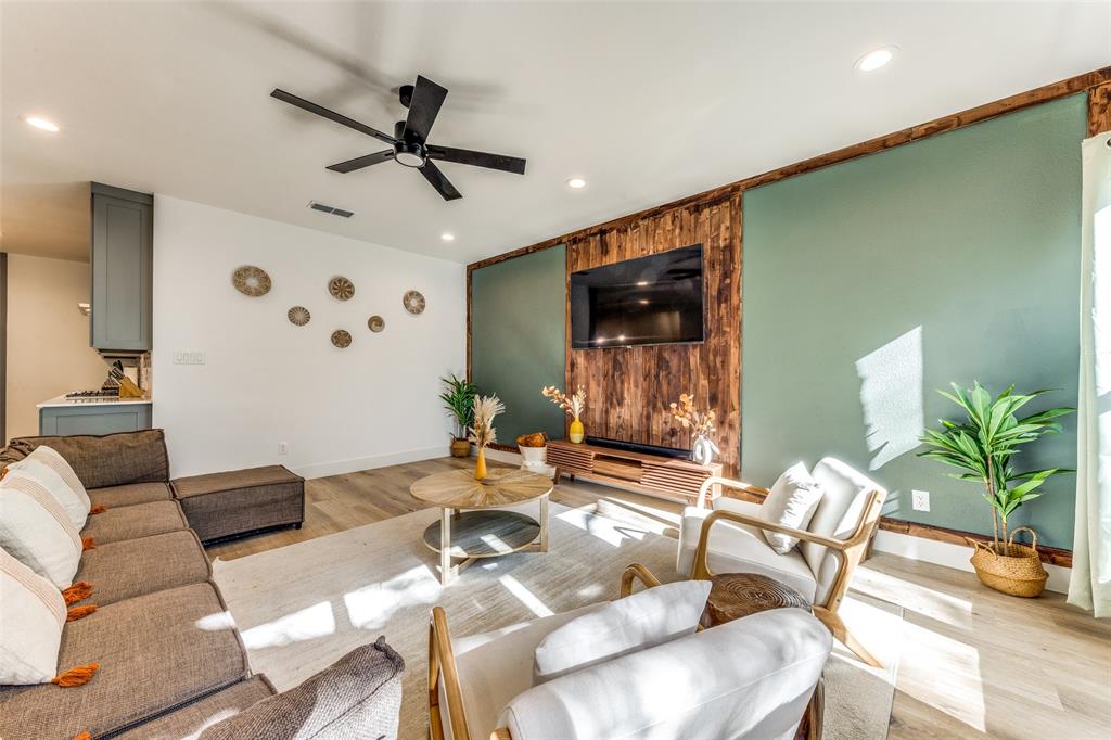 Living space featuring wood-finish flooring, recessed lighting, and a black ceiling fan