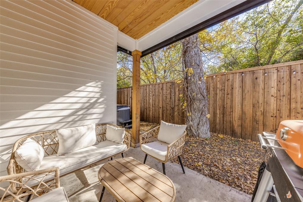 Private outdoor patio featuring a concrete slab and wood fence