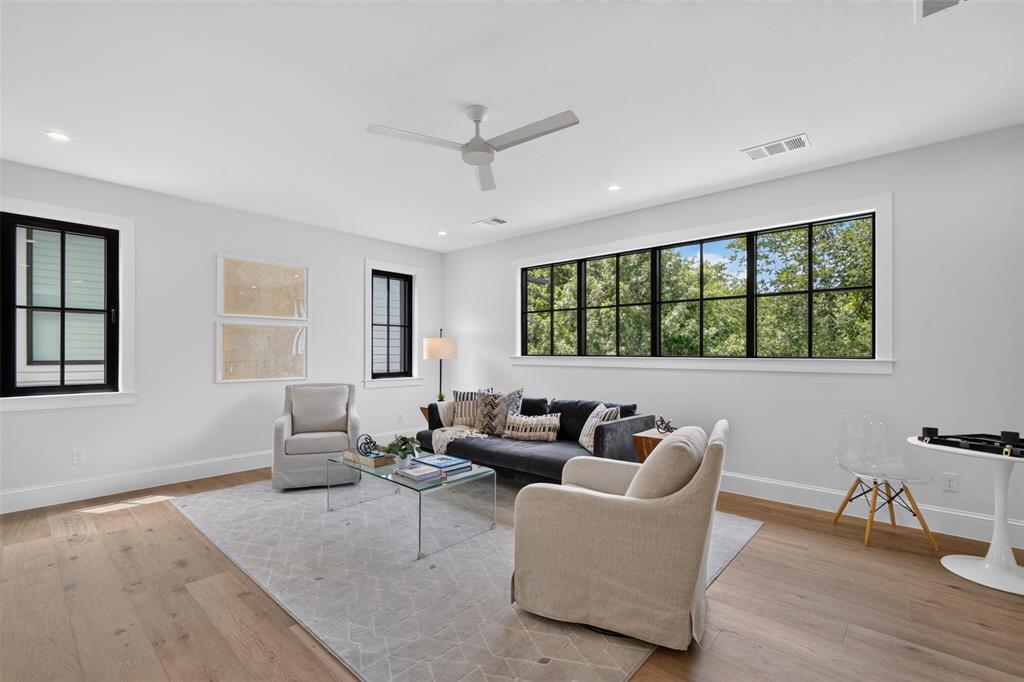 Spacious room featuring light wood-finish flooring, white walls, and recessed lighting