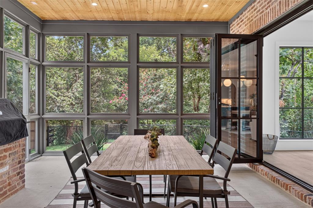 Screened porch featuring a wood-plank ceiling, concrete flooring, and extensive multi-pane windows